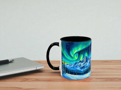 Mug with Northern Lights design on a wooden table with a laptop and pen.