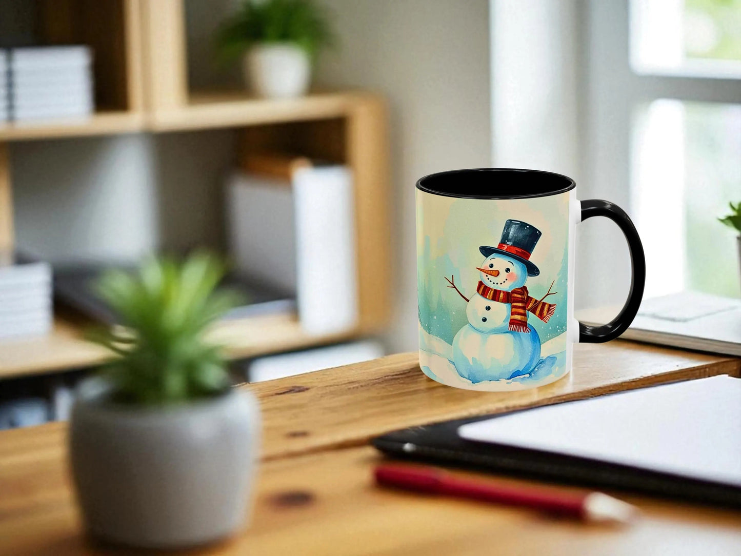 Mug with a snowman design on a wooden desk with a plant and tablet in the background