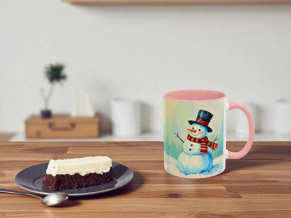 Mug with a snowman design on a wooden table with a slice of cake.