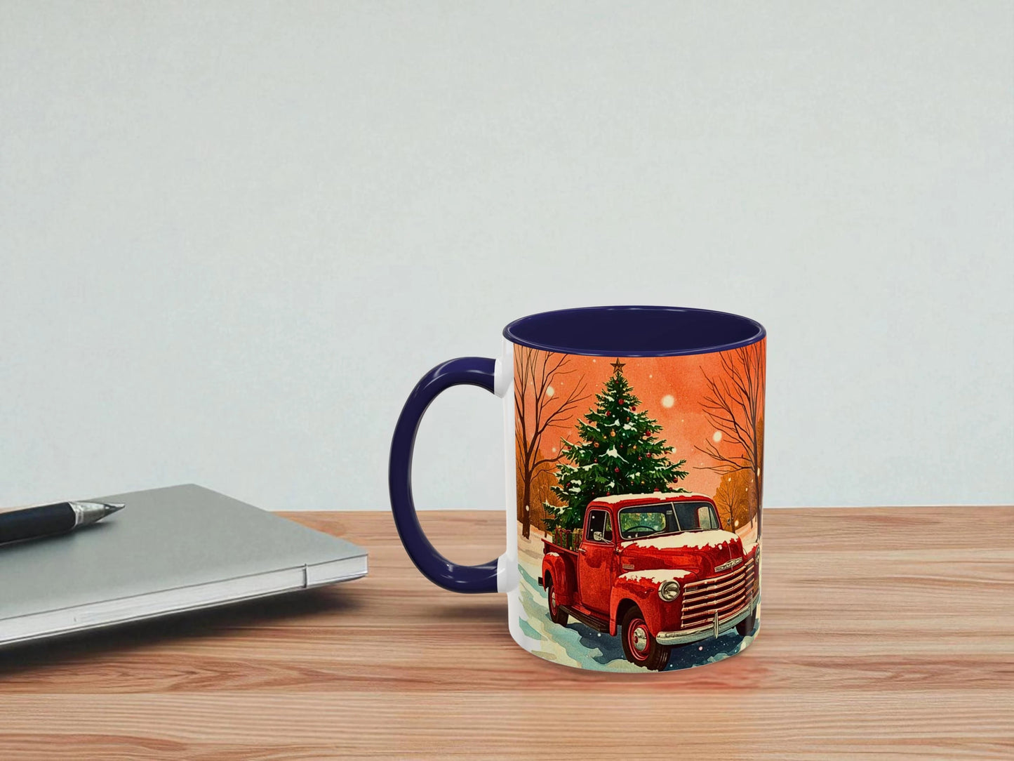 Mug with a Christmas design of a red truck and tree on a wooden table.