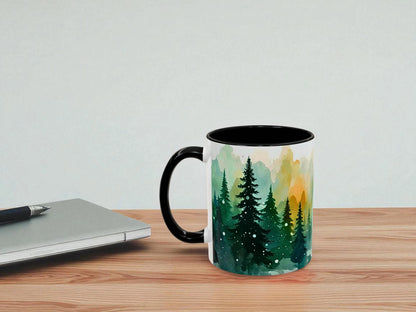 Mug with nature design on a wooden table next to a laptop.