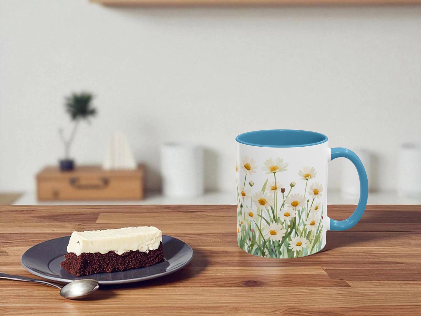 Mug with floral design on a wooden table with a slice of cake