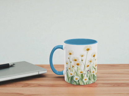 Mug with floral design on a wooden table next to a laptop.