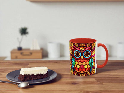 Colorful owl mug on a wooden table with a slice of cake and a spoon.