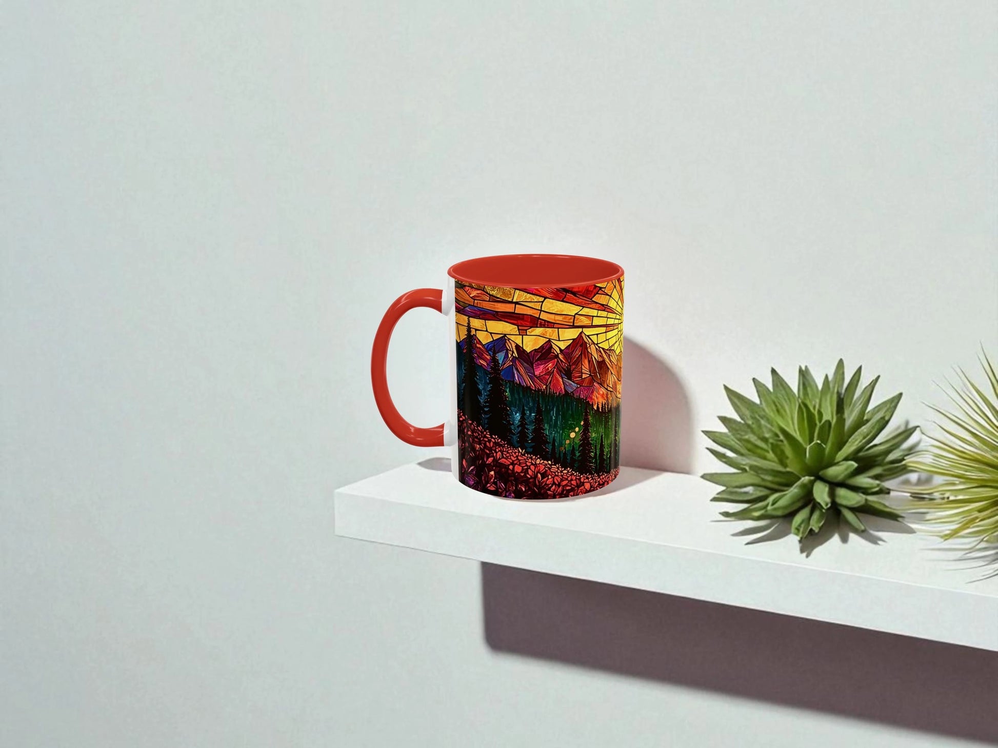 Mug with a colorful mountain design on a white surface with plants