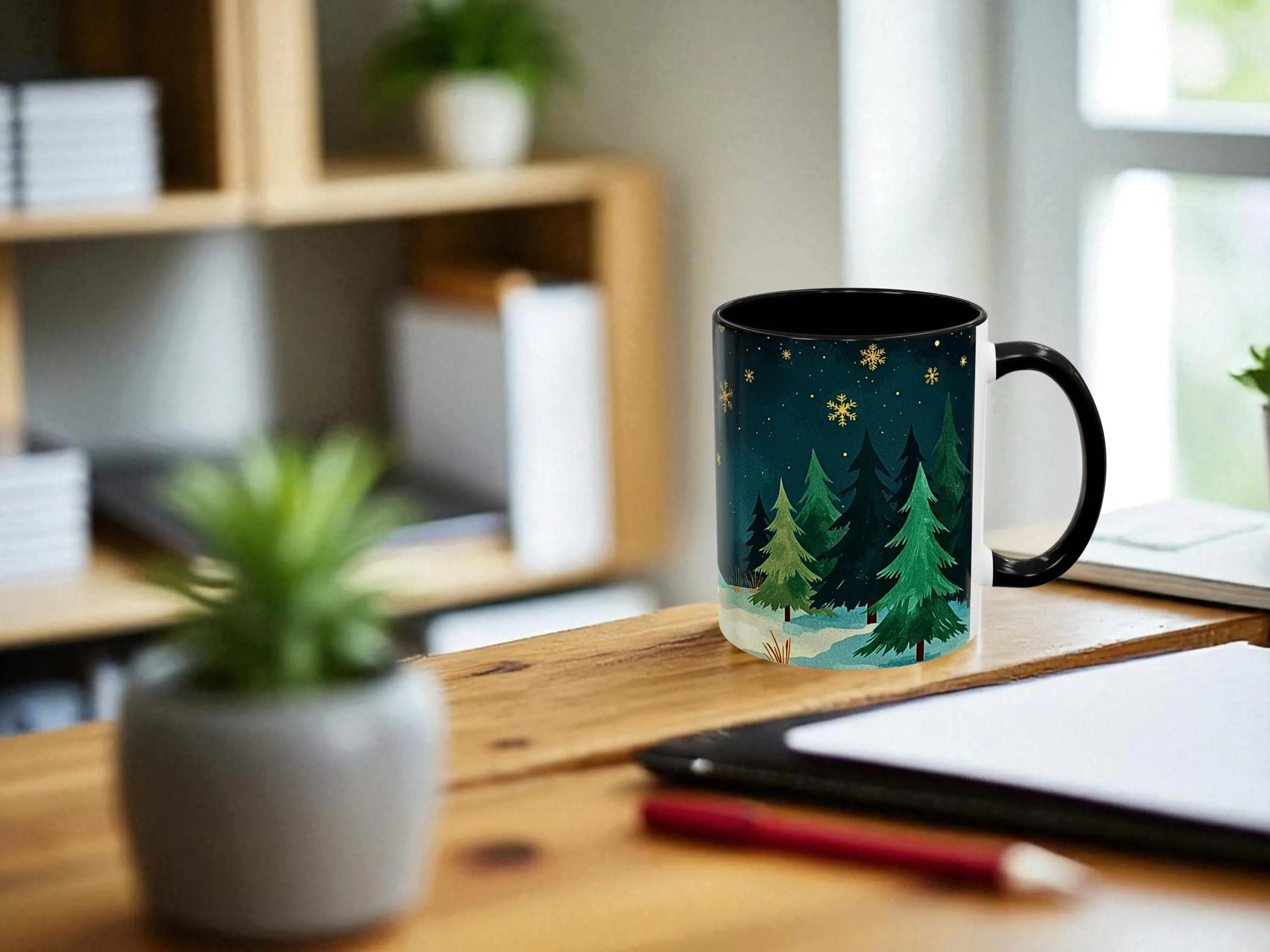 Mug with a forest design on a desk with a plant and tablet in the background