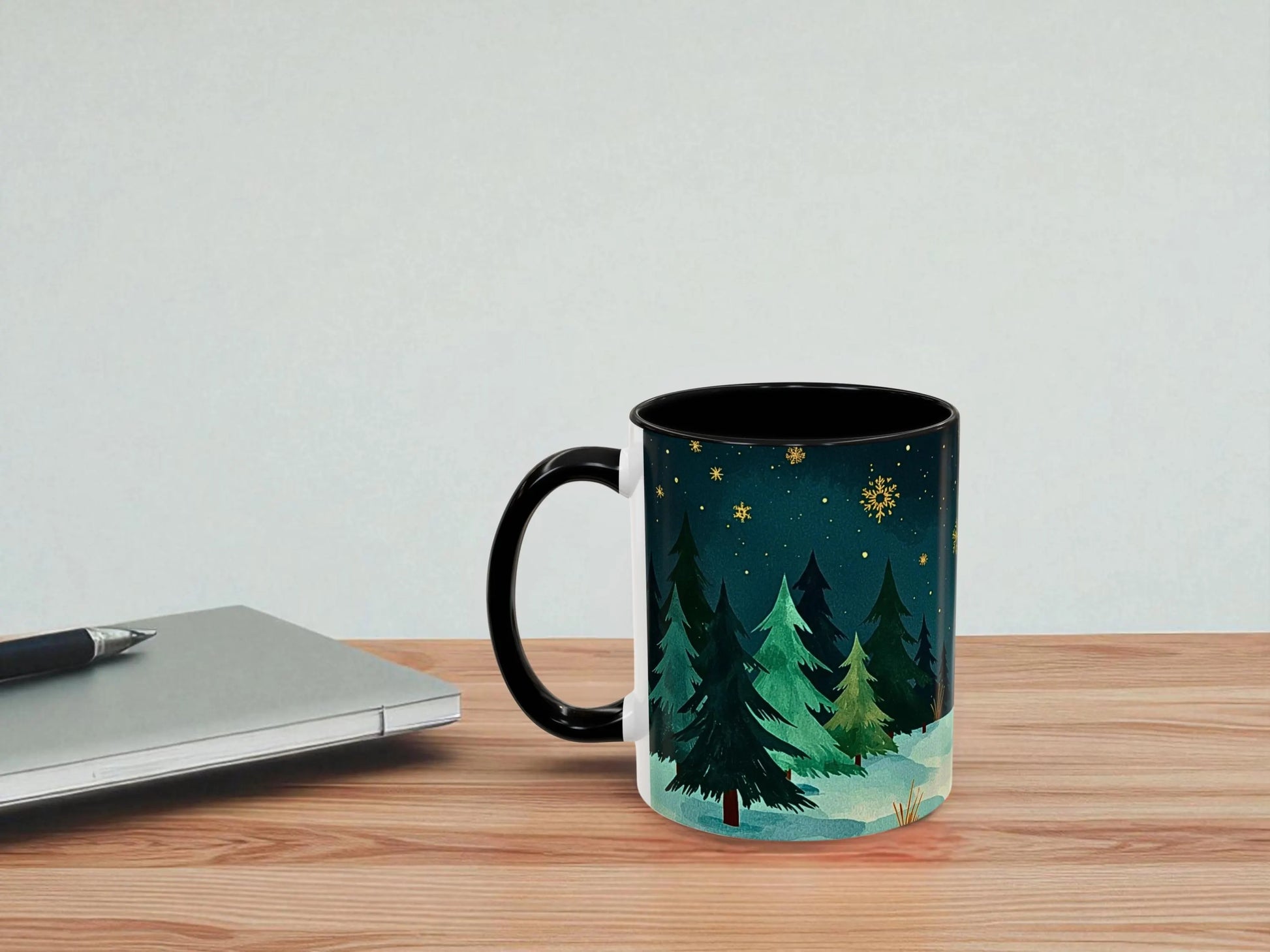 Mug with nature design on a wooden table next to a laptop