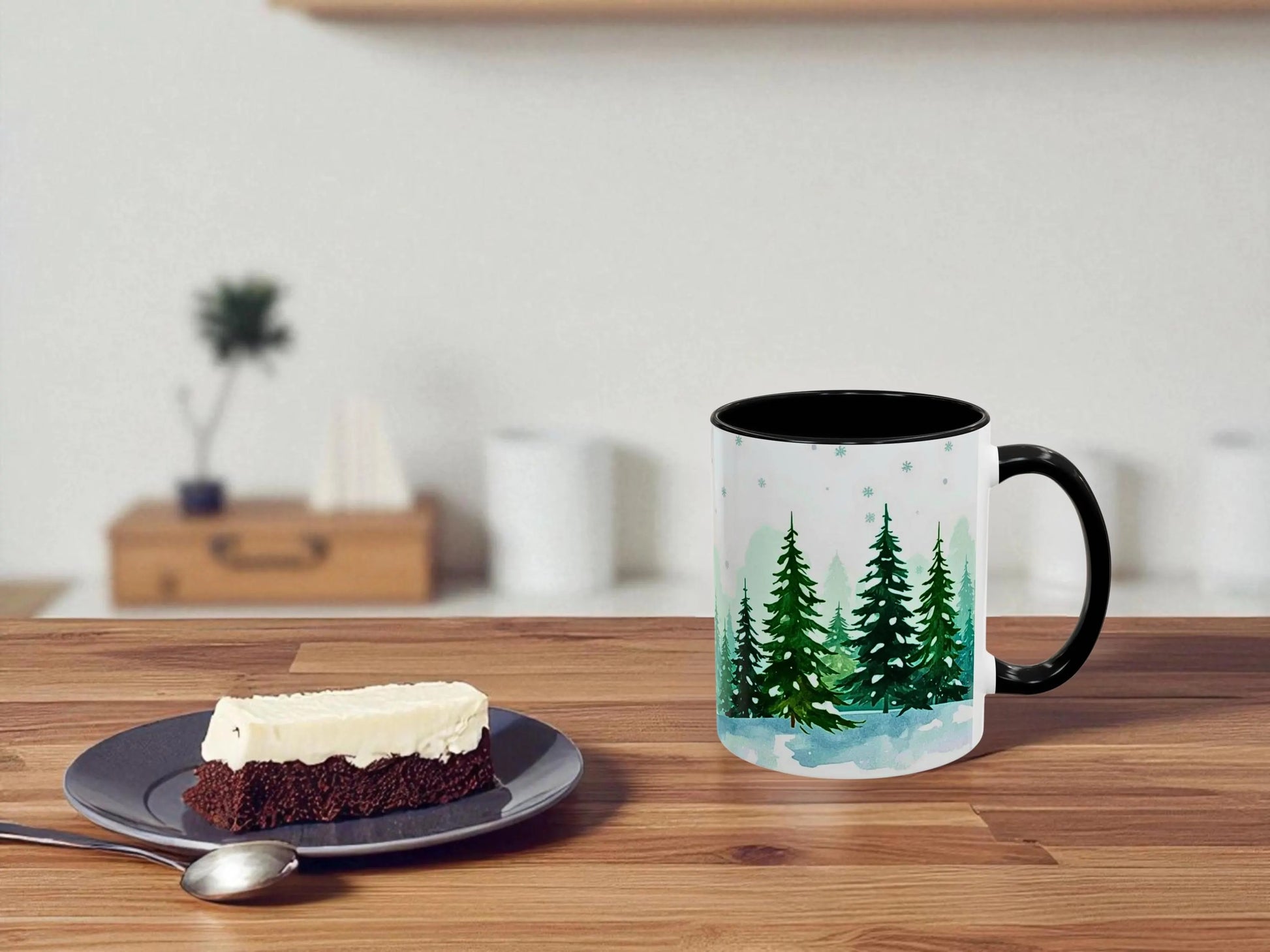 Mug with a forest design on a table next to a dessert