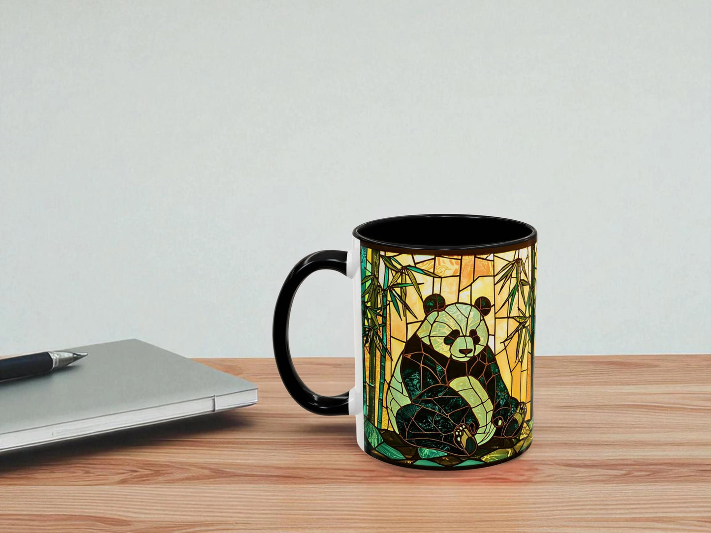 Mug with panda design on a wooden table next to a laptop