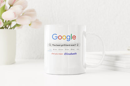 White mug with Google search bar design on a white surface with flowers in the background