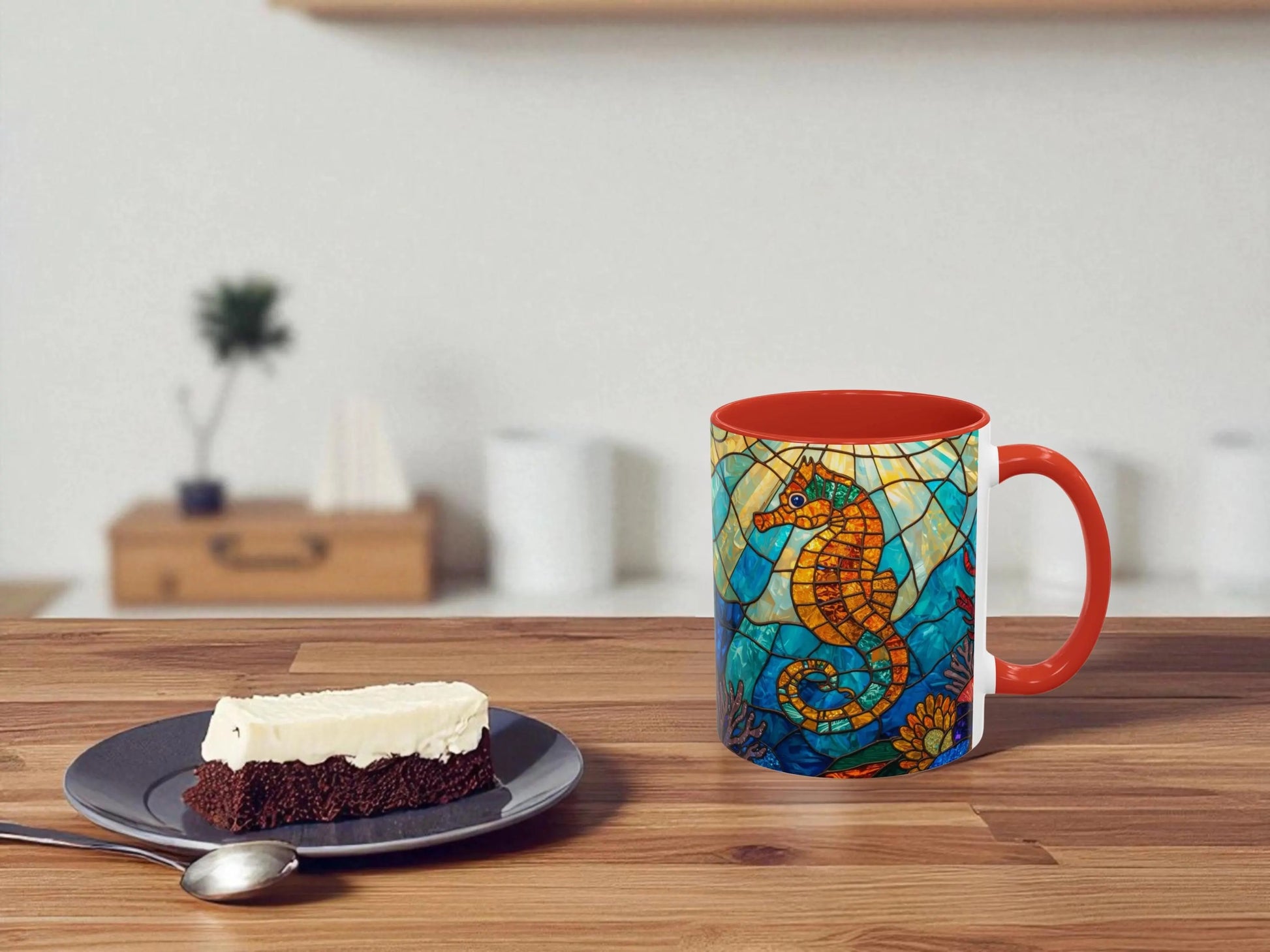 Colorful mug with a seahorse design on a wooden table next to a slice of cake.