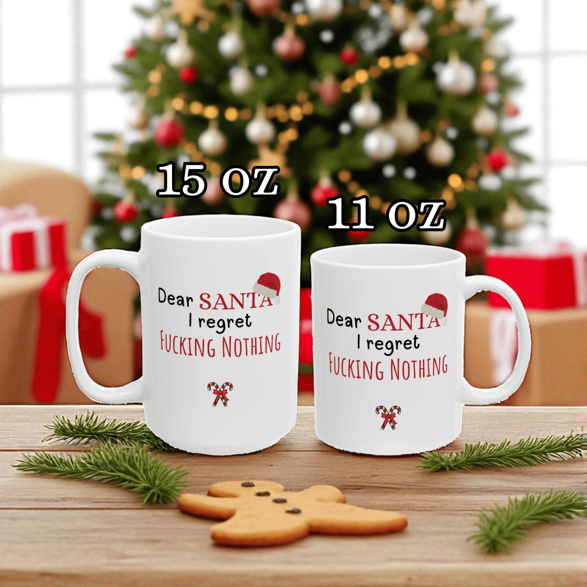 Two white mugs with humorous text in front of a Christmas tree and presents.