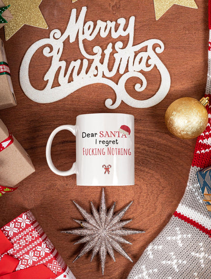 White mug with humorous text on a wooden surface with Christmas decorations