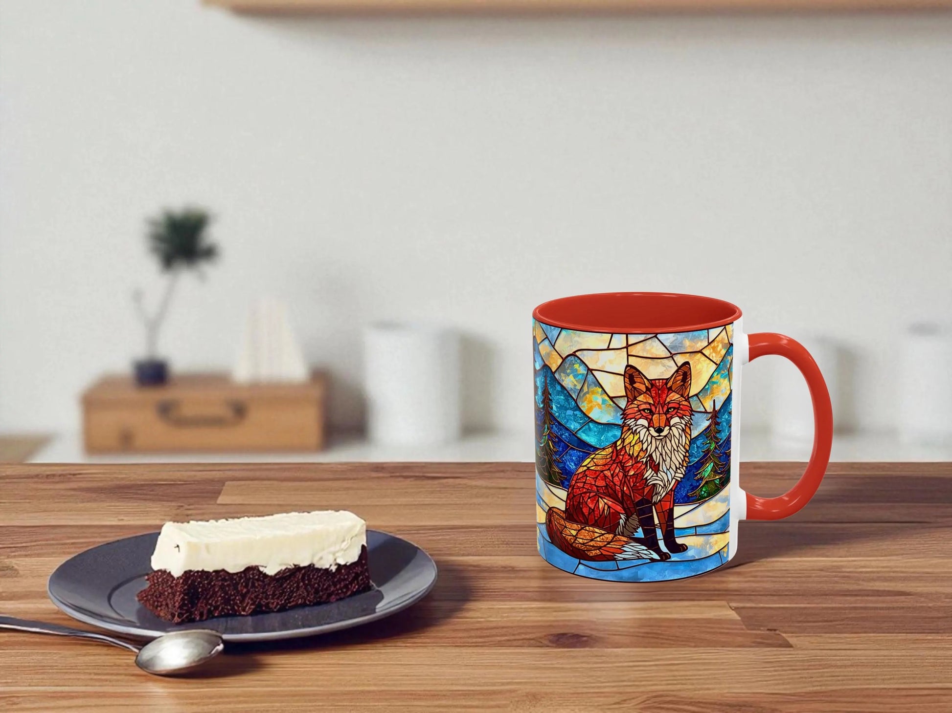 Mug with fox design on a wooden table with a slice of cake and spoon.