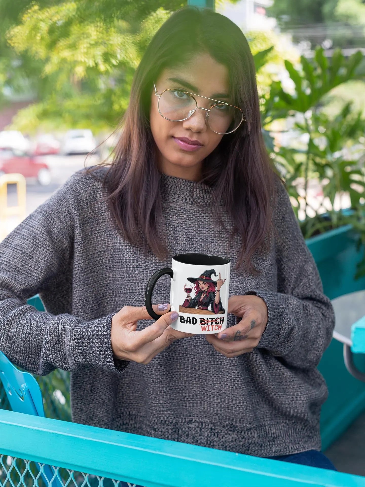 Person holding a mug with text and graphics outdoors