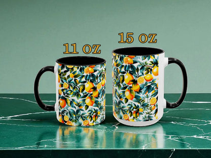 Two mugs with lemon pattern, one 11 oz and one 15 oz, on a green marble surface.
