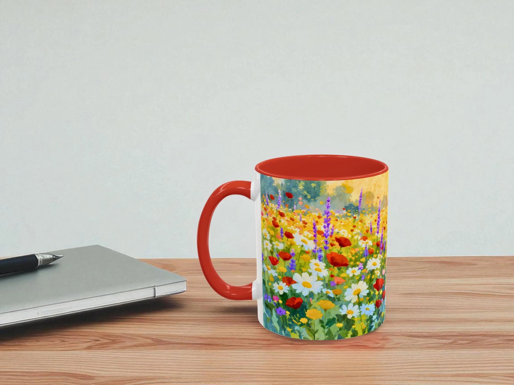 Mug with floral design on a wooden table next to a laptop.
