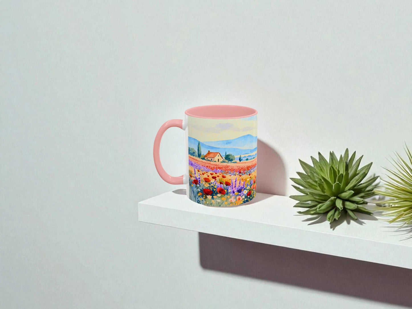Colorful mug with a scenic design on a white surface with plants