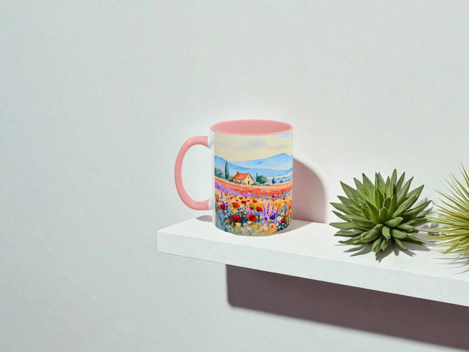 Colorful mug with a scenic design on a white surface with plants