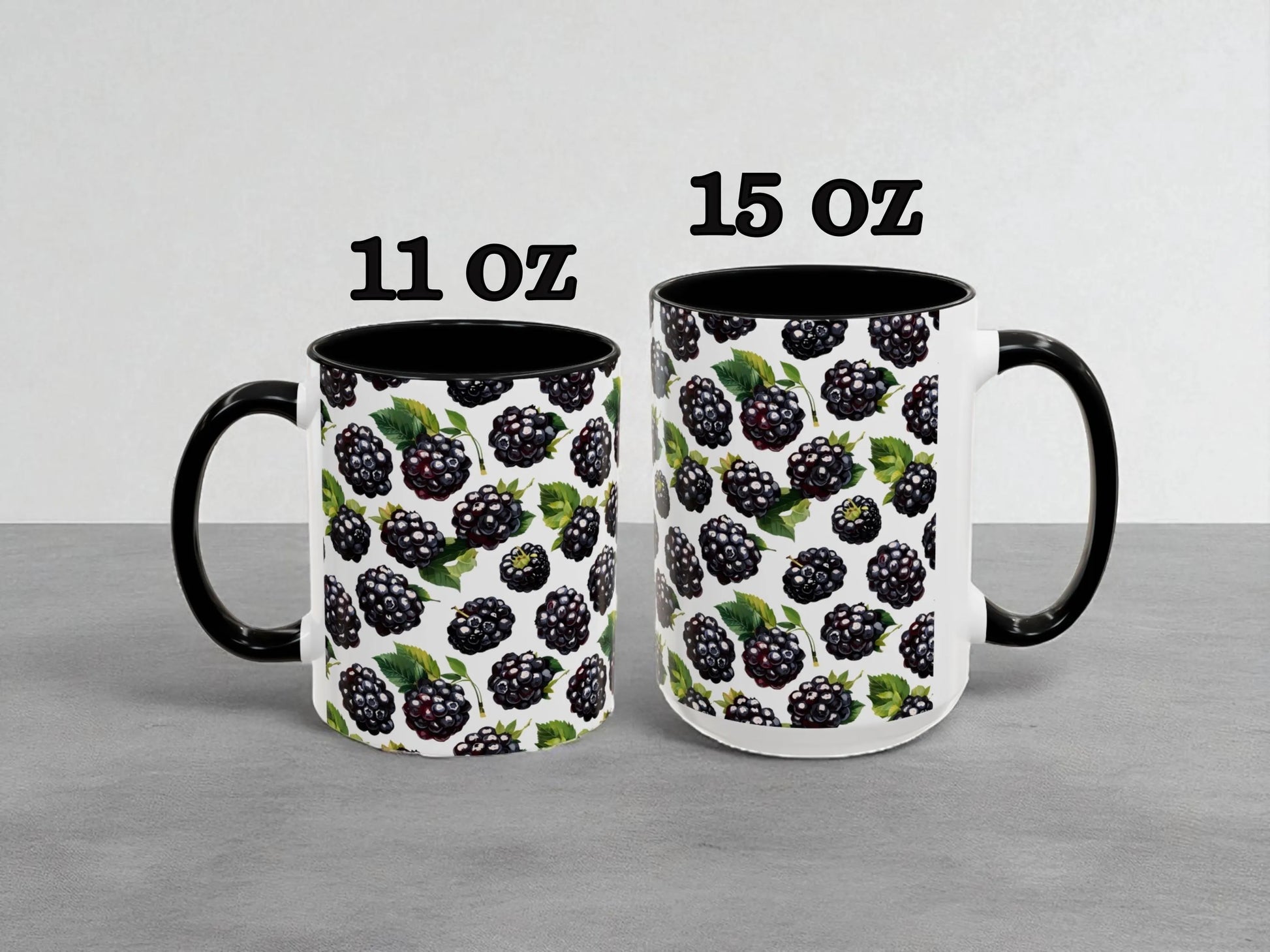 Two mugs with blackberry pattern, one labeled 11 oz and the other labeled 15 oz, on a gray background.