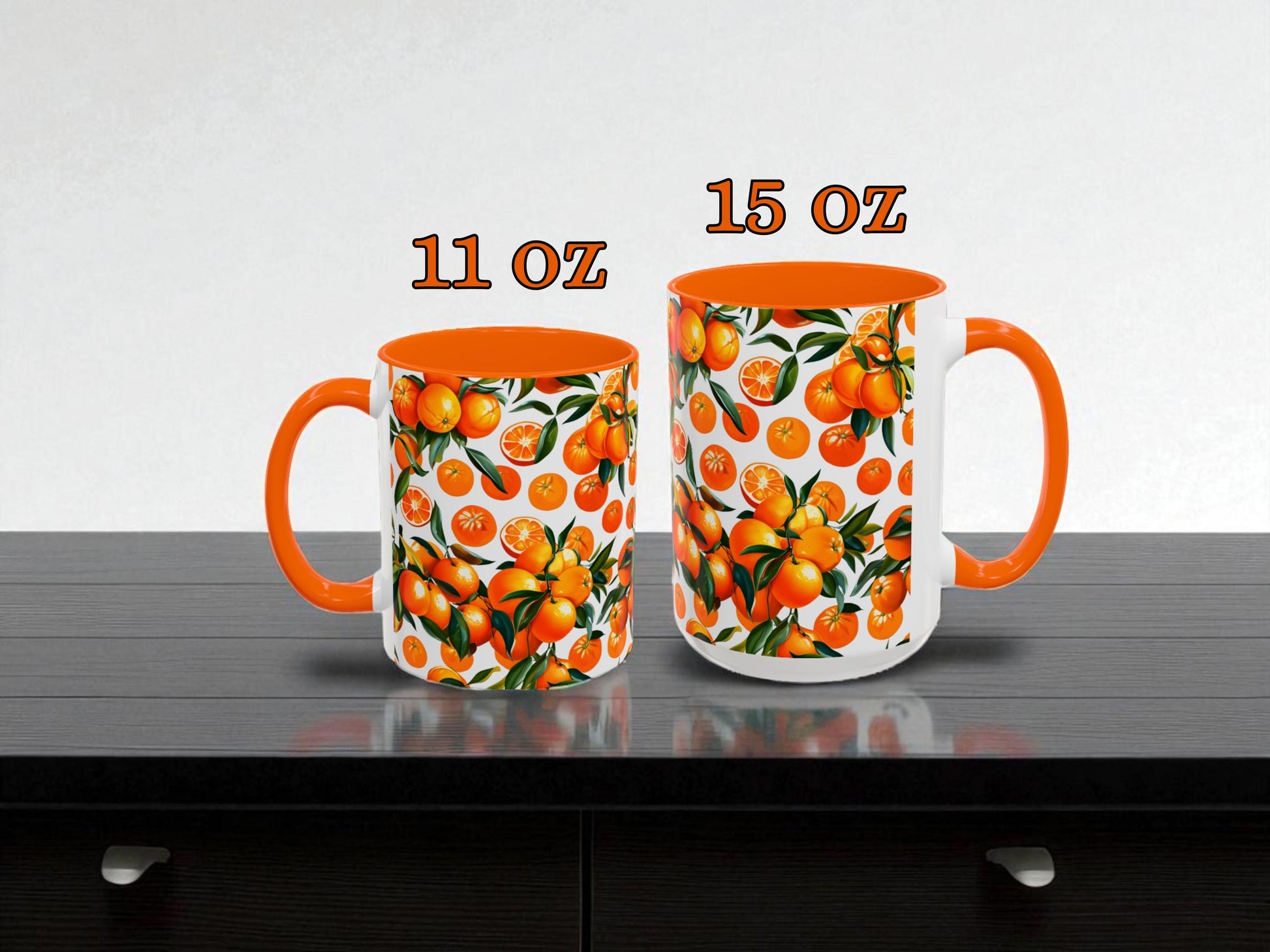 Two mugs with orange and white designs on a gray surface