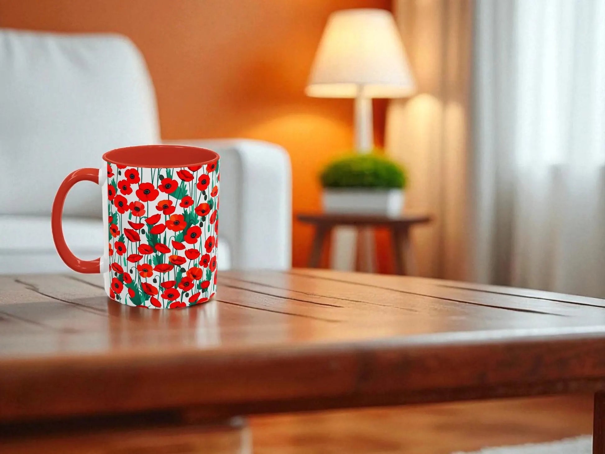 Red mug with floral pattern on a wooden table in a cozy living room.