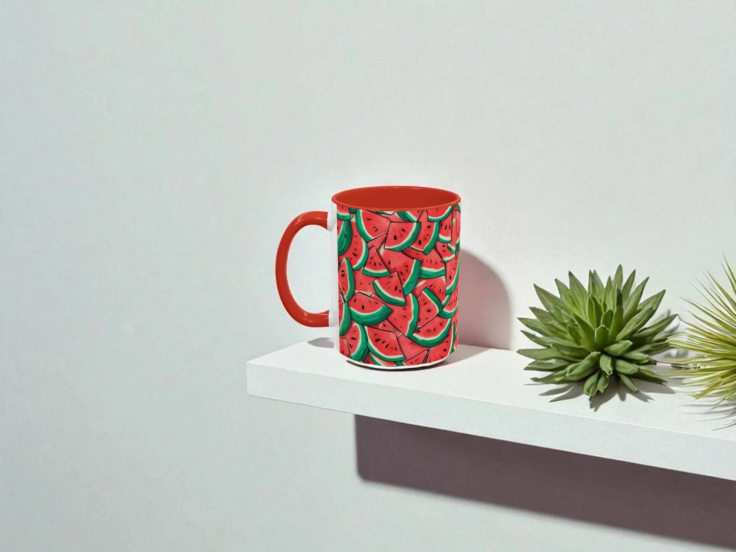 Red mug with watermelon pattern on a white shelf against a light gray background