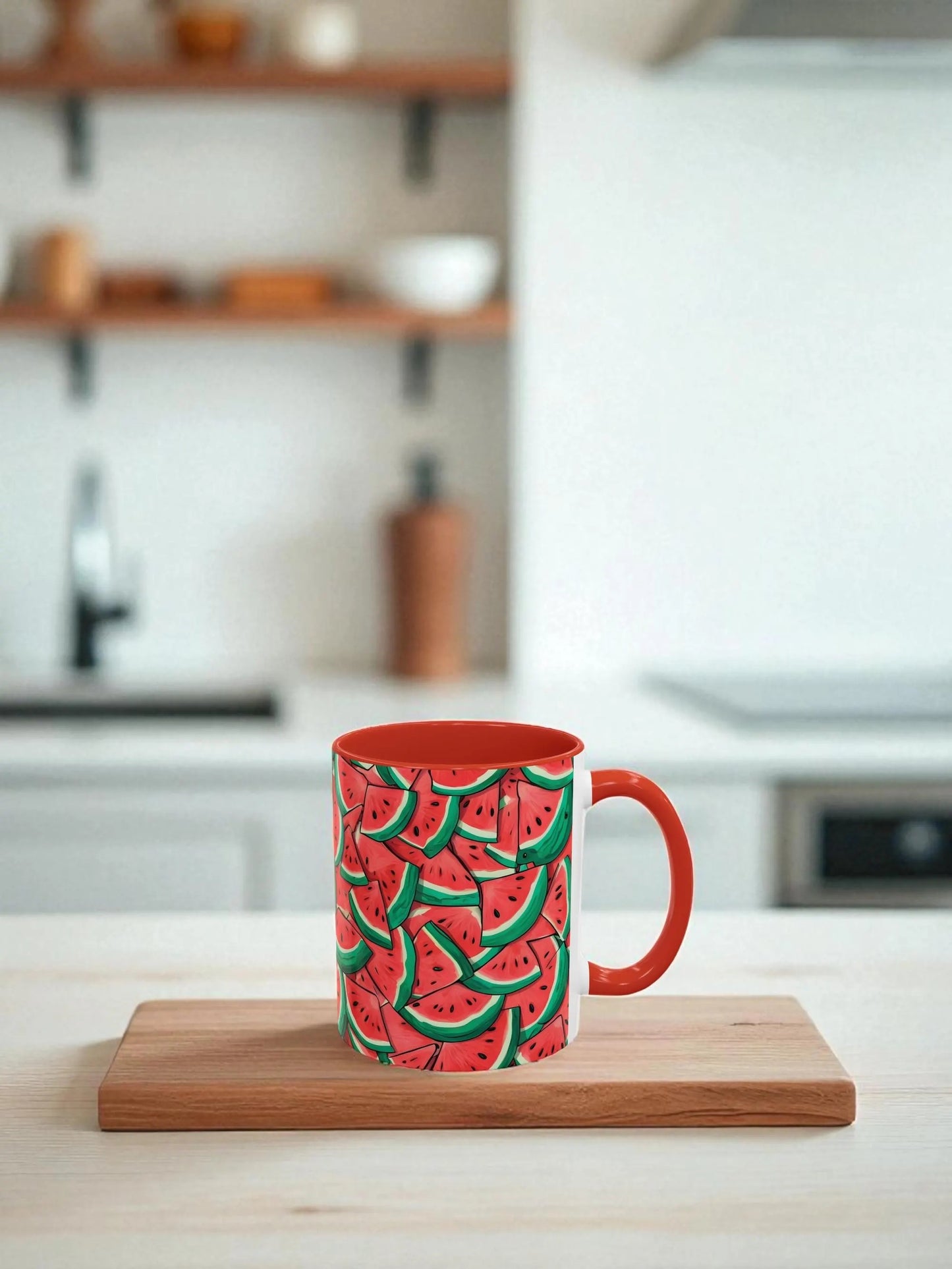Red mug with watermelon pattern on a white table in a bright kitchen.