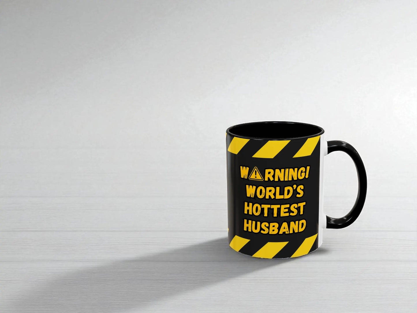 Black mug with yellow warning text on a white background