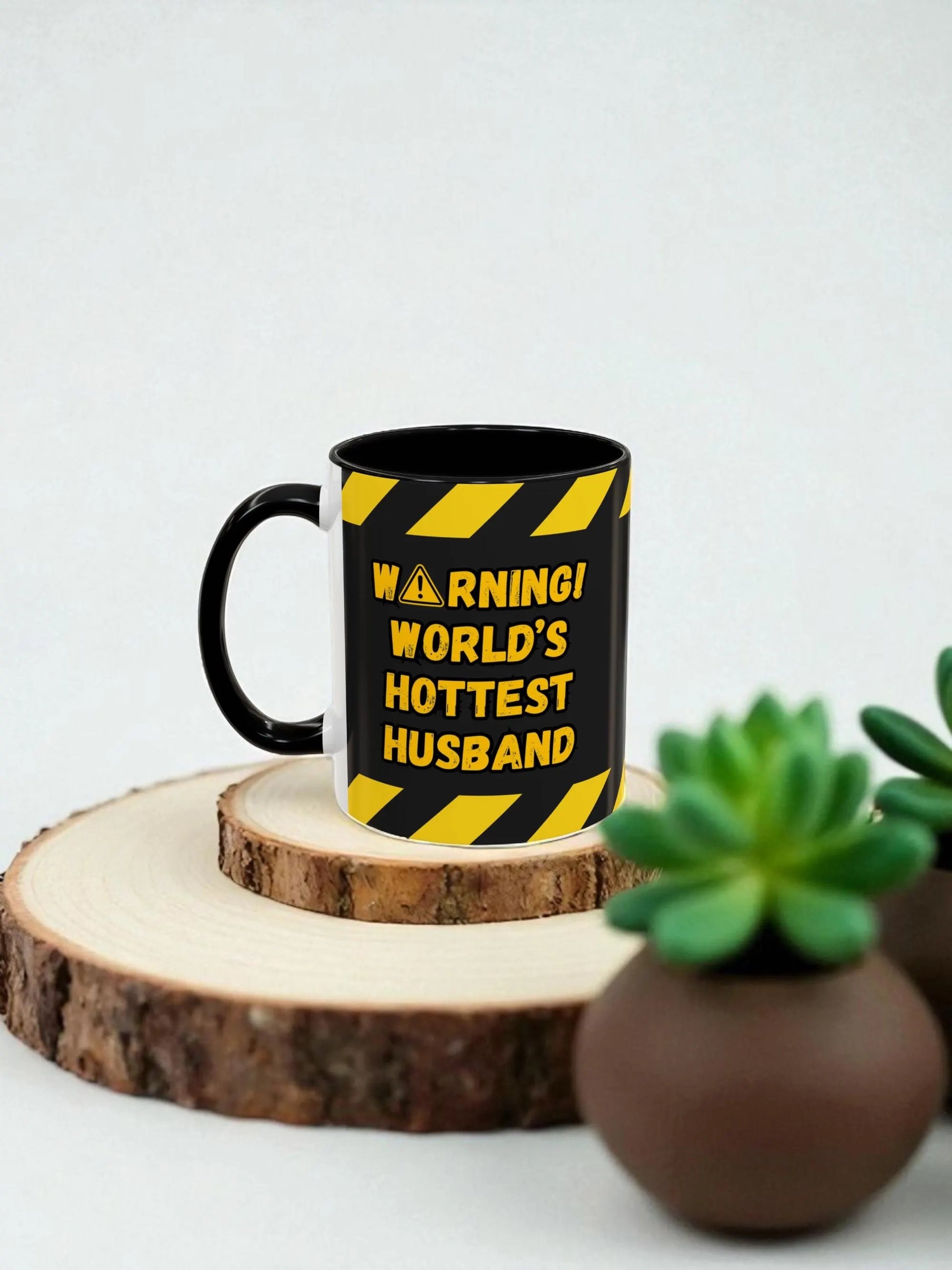 Black mug with yellow text and stripes on a wooden stand with a plant in the background