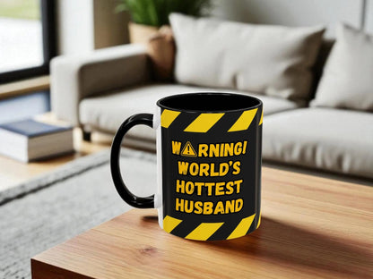 Mug with 'Warning: World's Hottest Husband' text on a wooden table in a living room setting.
