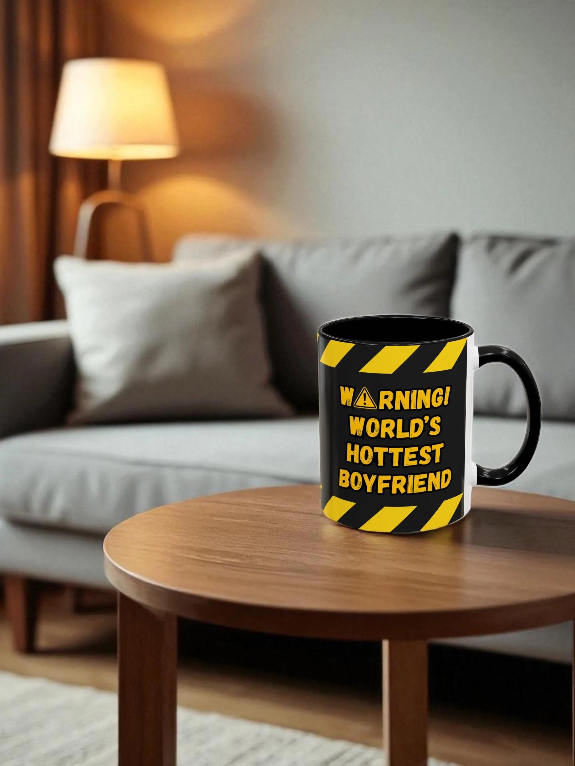 Mug with 'Warning! World's Hottest Boyfriend' text on a wooden table in a living room.