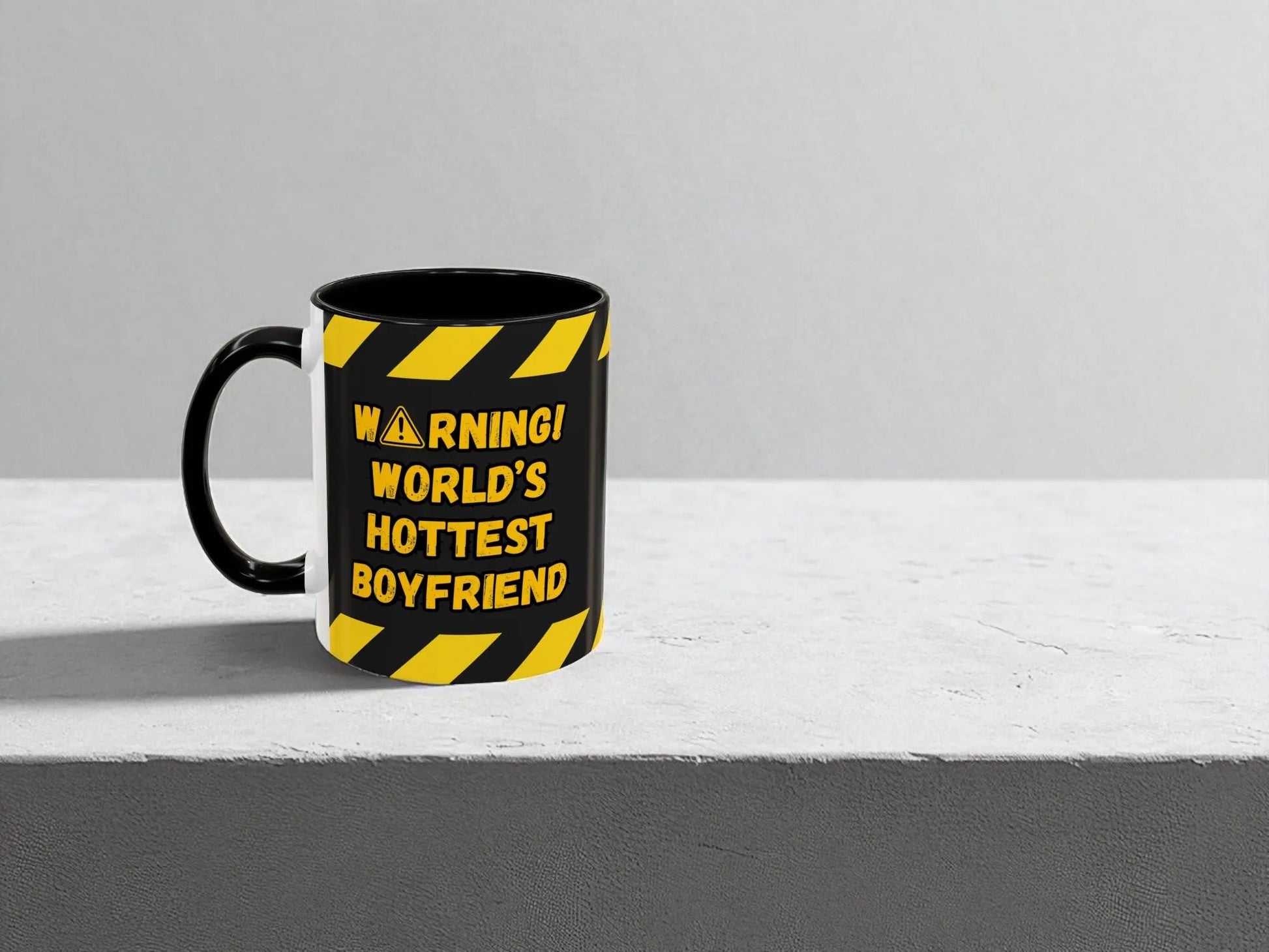 Black mug with yellow text and warning design on a gray background