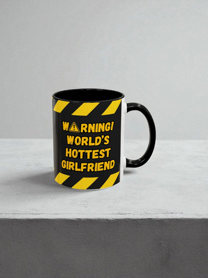 Black mug with yellow warning text on a gray background