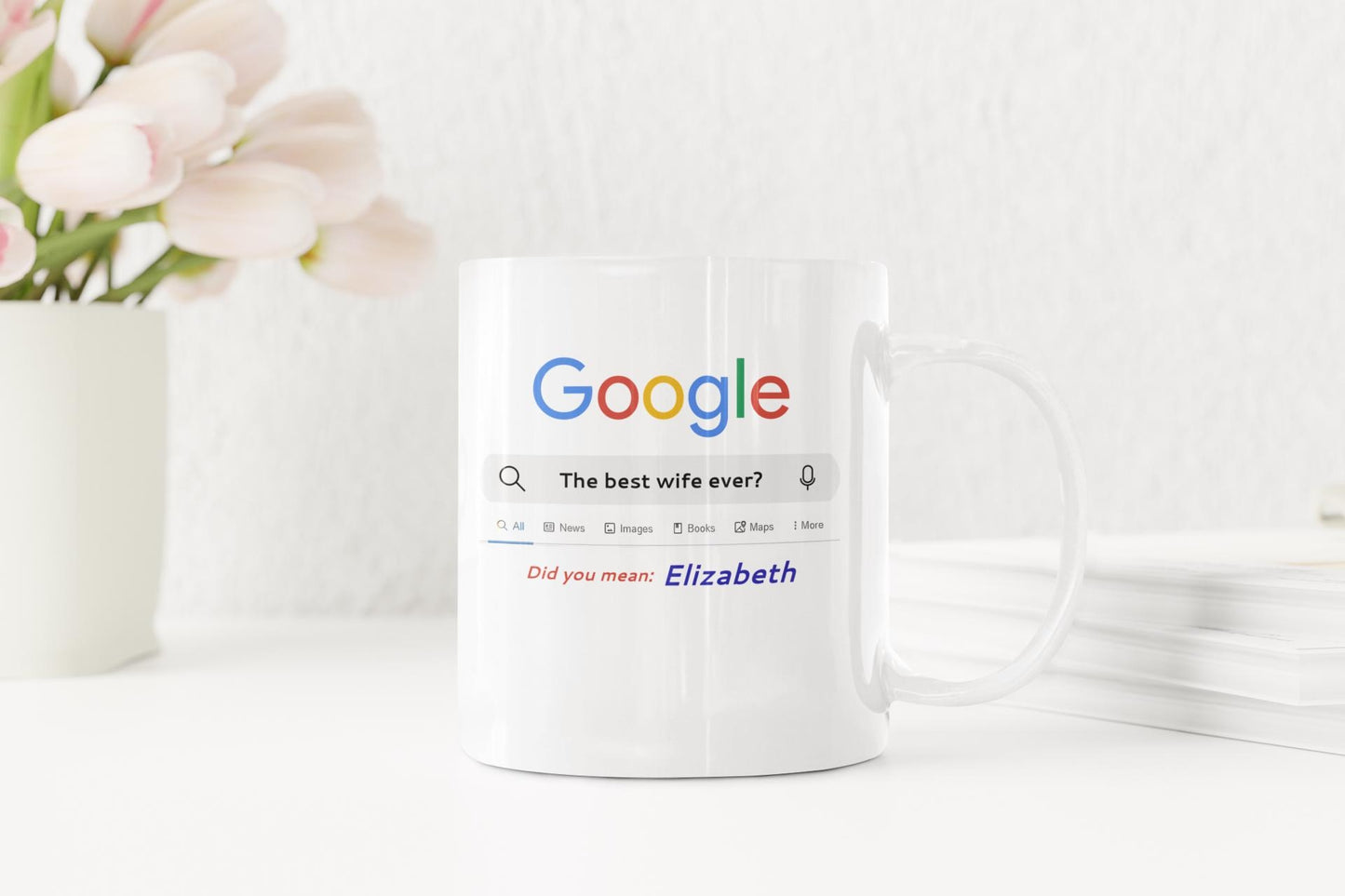 White mug with Google search bar design on a white surface with flowers in the background