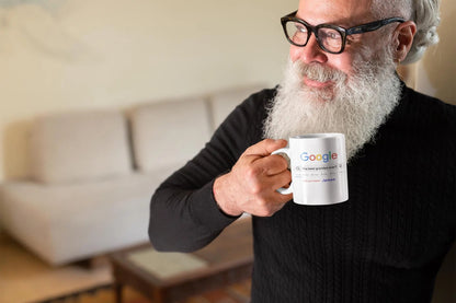 Man with a beard holding a Google mug in a living room setting