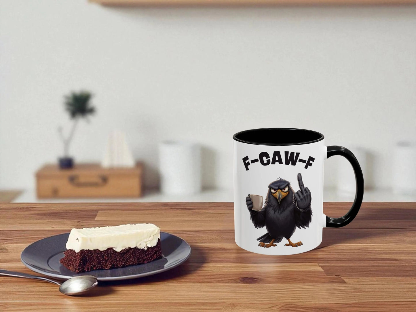 Mug with an eagle design and text on a table next to a piece of cake.